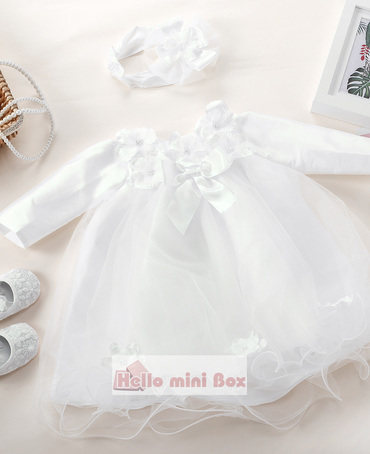 A short soft net christening dress with flowers and bows on the chest